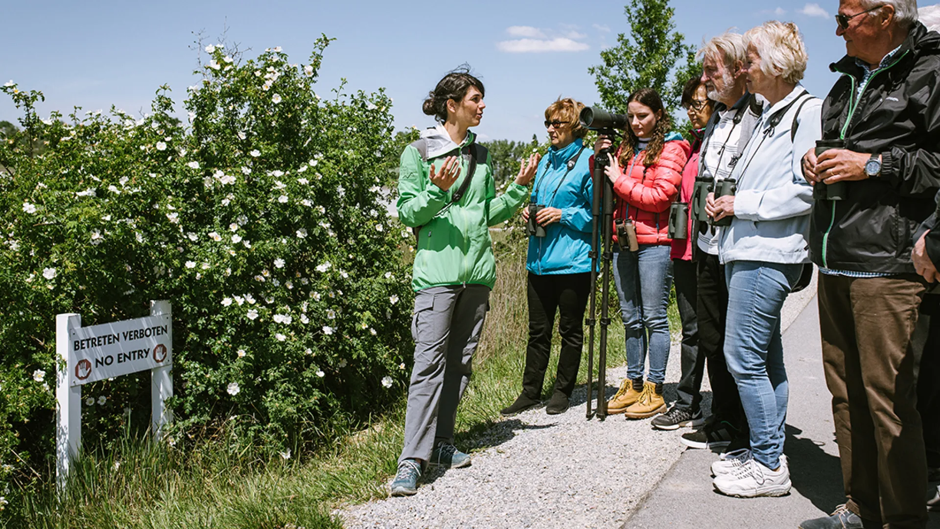 Rangerin erklärt einer kleinen Gruppe etwas