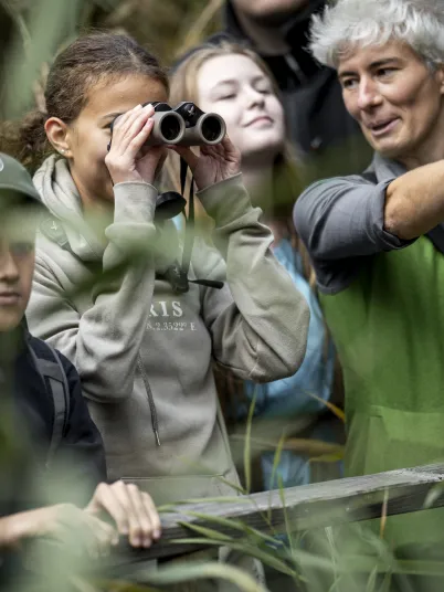 Ein Ranger zeigt Schülern etwas weit weg.