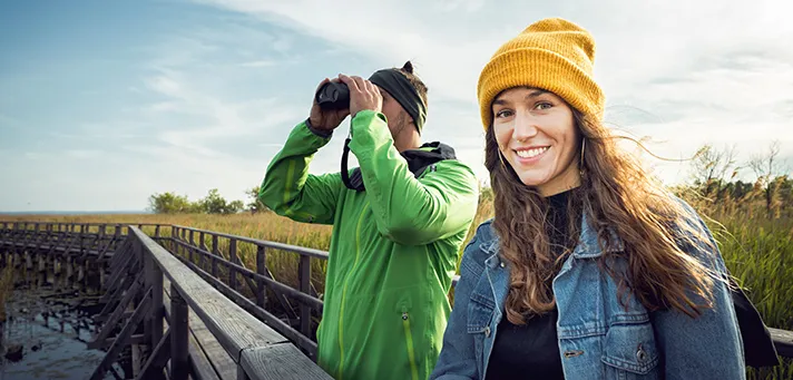 Zwei Personen beobachten mit einem Fernglas die Natur