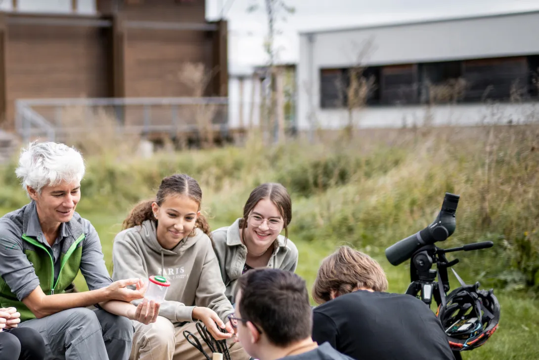 Junge Menschen beim Betrachten eines Insekts